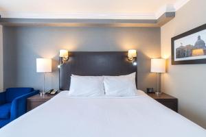 埃德蒙顿桑德曼签名埃德蒙顿南酒店的一间卧室配有一张白色大床和蓝色椅子