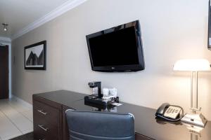 埃德蒙顿桑德曼签名埃德蒙顿南酒店的一间配有电视、椅子和电话的墙上客房