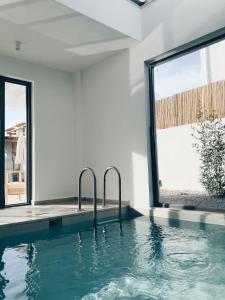 费特希耶Villa Neo with Jakuzi,indoor pool,sauna and floor heating的窗户房子中的游泳池