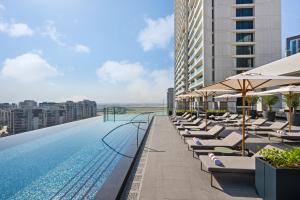 迪拜云溪港皇宫酒店的酒店游泳池设有躺椅和遮阳伞