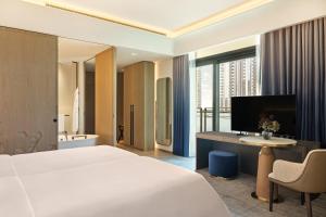 迪拜云溪港皇宫酒店的酒店客房配有一张床和一张书桌及一台电视