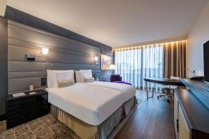 洛桑萨沃伊皇家Spa酒店的酒店客房设有一张大床和一张书桌。