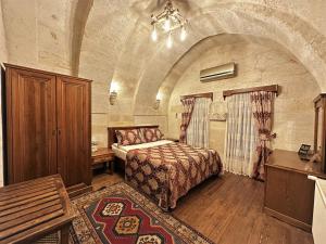 格雷梅石屋洞酒店的大房间中一间带床的卧室