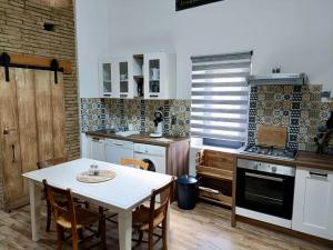 MontechL'Oustal的厨房配有白色的桌子和桌椅
