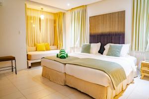 Cagraray米斯碧海湾的配有黄色窗帘的酒店客房的两张床