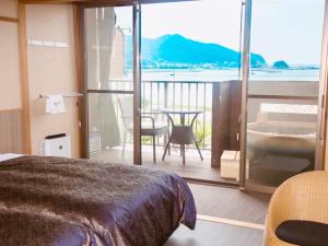 京丹后市LiVEMAX RESORT Kyotango Sea Front的一间卧室配有一张床,阳台配有桌子