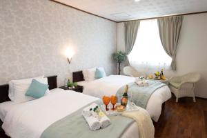 宫古岛宮古島　白宮別館的酒店客房设有两张床和窗户。