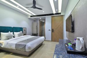 新德里Hotel Uptown - Near New Delhi Railway Station - Paharganj的一间卧室配有一张床和一台平面电视