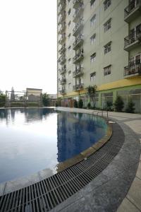 万隆Perfect Stay Apartement The Suites Metro Bandung By Sultan Property的大楼前的游泳池