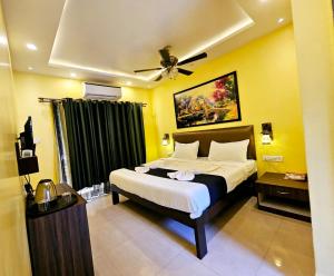 巴加Hotel Adam's Baga Beach Resort Goa - 2 minutes walk from Baga Beach的一间卧室配有一张床和吊扇