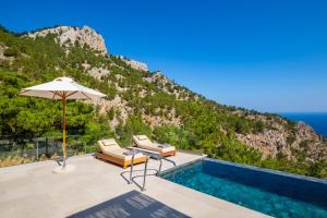 Kyra PanagiaMerTelia Luxury Villas的一座带游泳池和遮阳伞的别墅