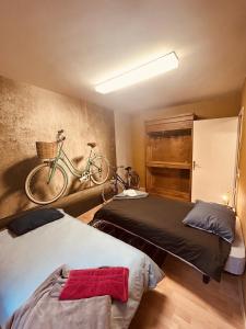 圣阿沃尔德LA MARIEFACTURE - Comme à Amsterdam的卧室配有两张床,墙上有一辆自行车