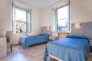 罗马Casa San Giuseppe的一间卧室设有两张床和两个窗户。