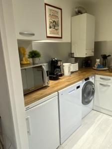 圣阿沃尔德LA MARIEFACTURE - Comme Chien et Chat的厨房配有洗衣机和微波炉。