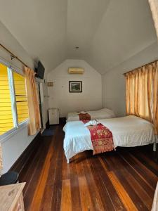 Ban Lam Thong LangBaan Rai Somkiat Homestay Saraburi的一间卧室设有两张床,铺有木地板