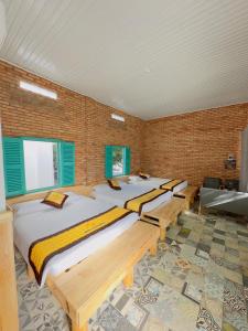 潘郎Ninh Chu 2 Hotel的砖墙内一间卧室,配有四张床