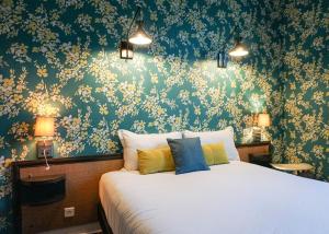戛纳戛纳中心普鲁伊别墅酒店的一间卧室配有一张带花卉壁纸的床