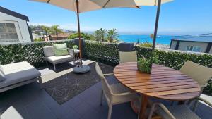 莫塞尔湾Mosselbay Dream Home的庭院配有桌椅和遮阳伞。