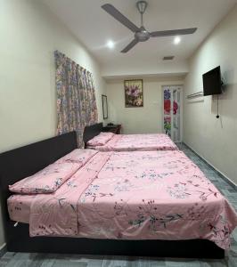 和丰西子楼 CZI Budget Hotel Sungai Siput的卧室配有粉红色的床和吊扇