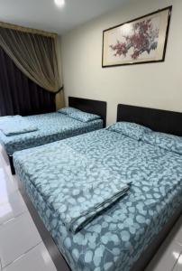 和丰西子楼 CZI Budget Hotel Sungai Siput的两张位于酒店客房的床,配有蓝色棉被