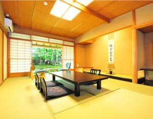 新发田市Ryokan Imai的客房设有桌椅和窗户。