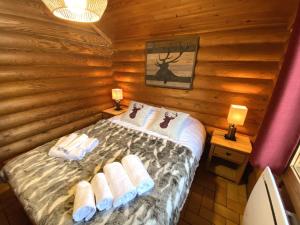 拉布雷斯LE GRAND CERF Chalet en rondins avec SPA Jacuzzi的小木屋内一间卧室,配有一张床