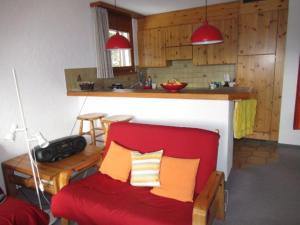 伦策海德Bot Sundroina (326 Sh) Whg. 2.1的一间带红色沙发的客厅和一间厨房