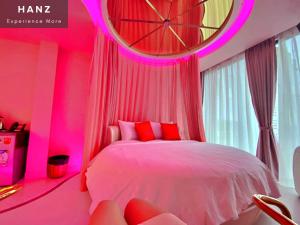 胡志明市HANZ MeGusta Hotel Ben Thanh的粉红色的卧室,配有床和大时钟