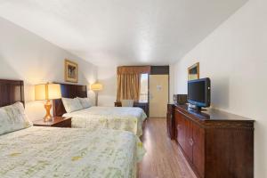 威廉斯堡Williamsburg Suites的酒店客房设有两张床和一台平面电视。