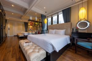 河内Golden Legend Boutique Hotel的卧室配有一张白色的大床和一张沙发。