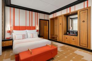 巴库Dinamo Hotel Baku的一间卧室配有一张床和一个橙色的搁脚凳