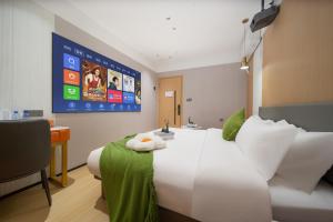 广州广州雅舍酒店（科韵路地铁站琶洲会展店）的一间酒店客房,配有白色的床和电视