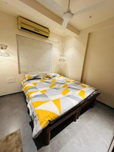 班加罗尔The Pent - Richmond的一间卧室配有一张黄色和白色的被子。