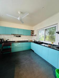 班加罗尔The Pent - Richmond的厨房配有蓝色橱柜和吊扇