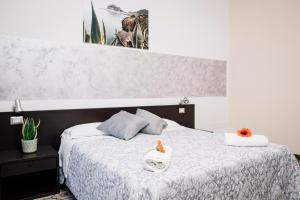 切法卢铝佩斯卡托酒店的一间卧室配有白色床单和橙色鲜花。