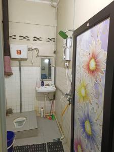 Kuala BerangHomestay Sejati的浴室设有墙壁上花卉装饰的淋浴。
