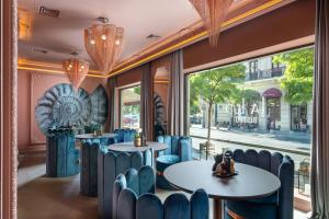 布加勒斯特VISIONAPARTMENTS Bucharest Calea Victoriei的餐厅设有蓝色的桌椅和窗户。