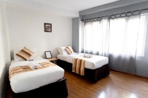 帕坦Nyadha House Bed & Breakfast的酒店客房设有两张床和窗户。