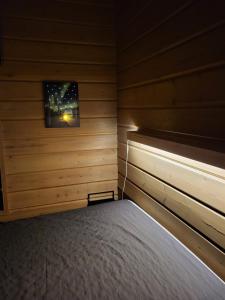 鲁卡Tunturipöllö 4的木制客房内的一间卧室,配有一张床