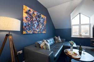 格洛斯特Elliot Oliver - Loft Style 2 Bedroom Apartment With Parking In The Docks的客厅配有沙发和墙上的绘画
