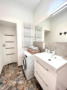 博莱斯瓦维茨BoleslaviaApartments - Apartament Starówka 1的白色的浴室设有洗衣机和水槽。