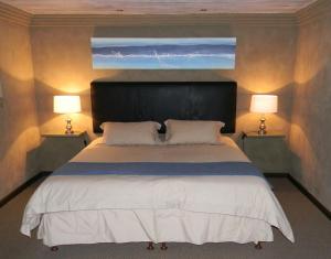 BuffeljagsrivierStonehill River Lodge by Dream Resorts的一间卧室配有一张大床和两盏灯