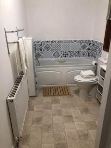 莫尔顿Chestnut Lodge With Hot Tub的浴室配有白色浴缸和卫生间。