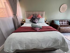 比勒陀利亚Afrique134 Olive Tree Private Courtyard Suite的一间卧室配有一张大床和两个枕头