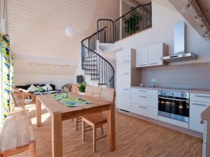 BrackenheimWinzercafe Neipperg Ferienwohnungen的厨房以及带木桌和椅子的用餐室。