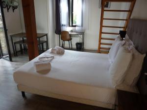 科尔特Apparts' hôtel Casa di a Restonica的卧室配有带毛巾的大型白色床