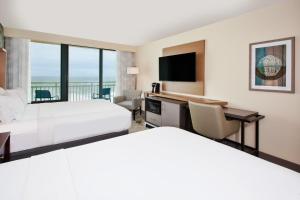 弗吉尼亚海滩Holiday Inn Va Beach-Oceanside 21st St, an IHG Hotel的酒店客房设有两张床和一台平面电视。
