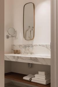 斯鲁伊斯De Lindenhoeve Boutique Hotel的浴室配有带镜子的盥洗盆和毛巾