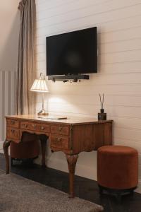 斯鲁伊斯De Lindenhoeve Boutique Hotel的一间设有一张桌子的房间,墙上有一台电视机