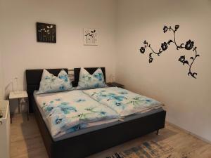 斯皮特安德劳Pension Hexagon的一间卧室,床上摆放着蓝色鲜花
